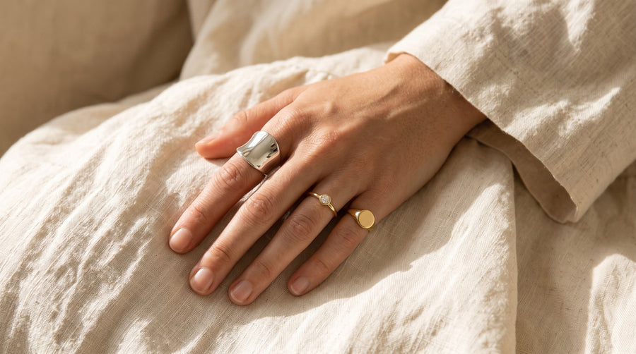 Ring finger meaning illustrated: a hand wearing a thumb ring, a promise ring and a pinky signet ring