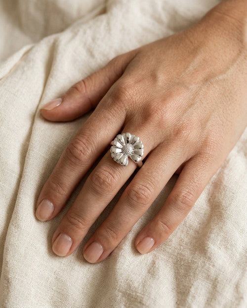 Statement daisy ring worn on the middle finger