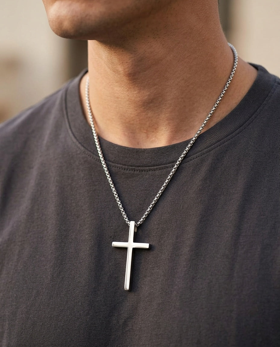 Men's cross necklace worn over a T-shirt