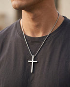 Men's cross necklace worn over a T-shirt