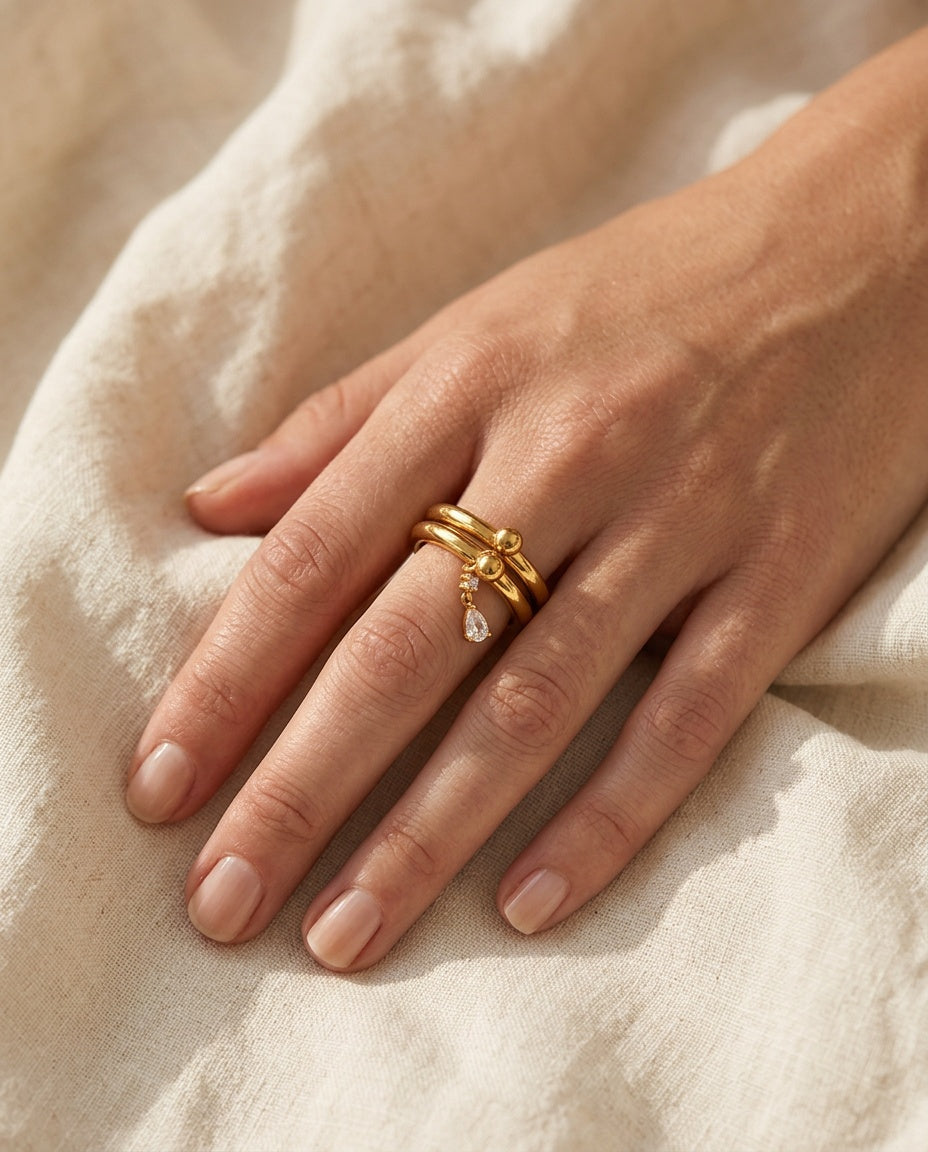 Charm ring worn on the index finger with a light ring stack