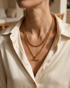 Woman wearing a gold double chain with T-bar pendant on an open neckline