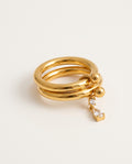 Gold charm ring with two slim bands and a dangling zirconia teardrop