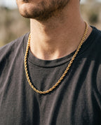 Chaîne dorée à maille corde portée par un homme sur un t-shirt blanc