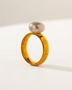 Gold pearl ring with a round shell pearl on a smooth band