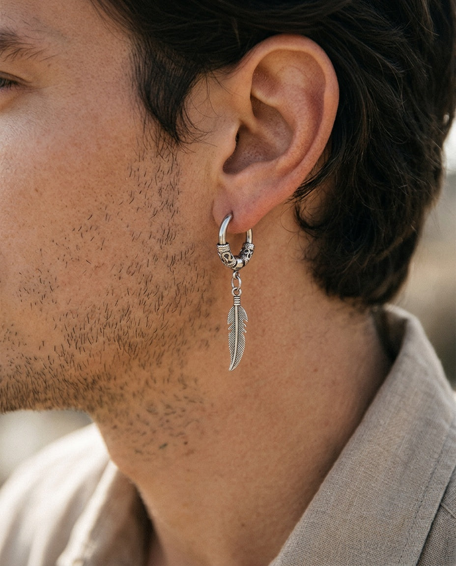 Feather dangle earring worn on a man's ear