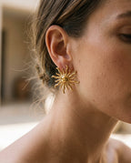 Sun earrings worn with hair pulled back