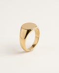 Gold signet ring with a smooth oval face, polished, on white