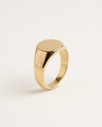 Gold signet ring with a smooth oval face, polished, on white