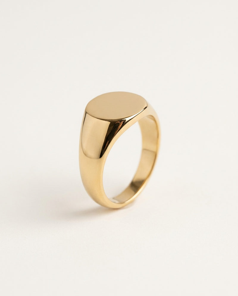Gold signet ring with a smooth oval face, polished, on white