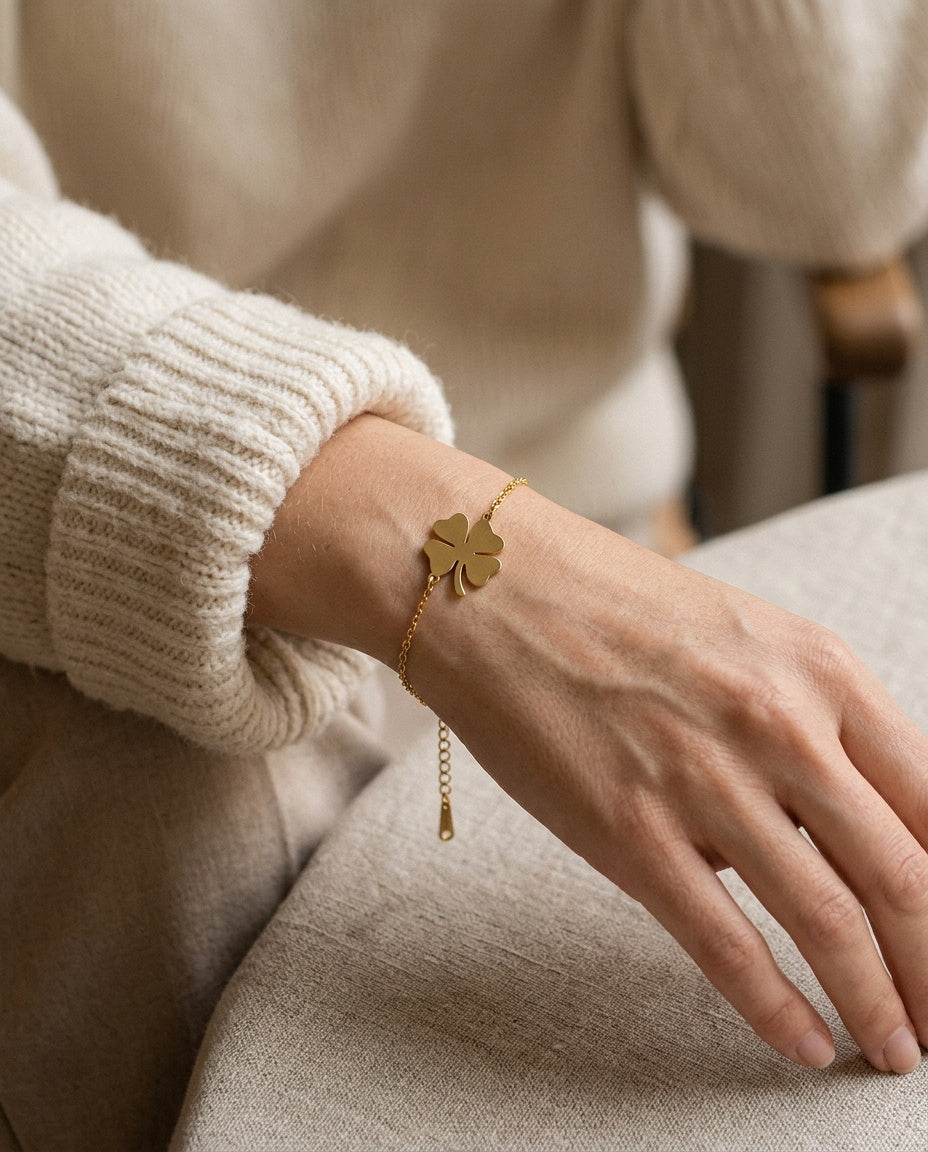 Bracelet femme trèfle porté au poignet avec d'autres bracelets dorés