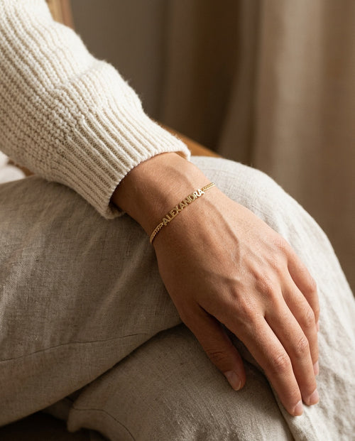 Name bracelet worn on a woman's wrist