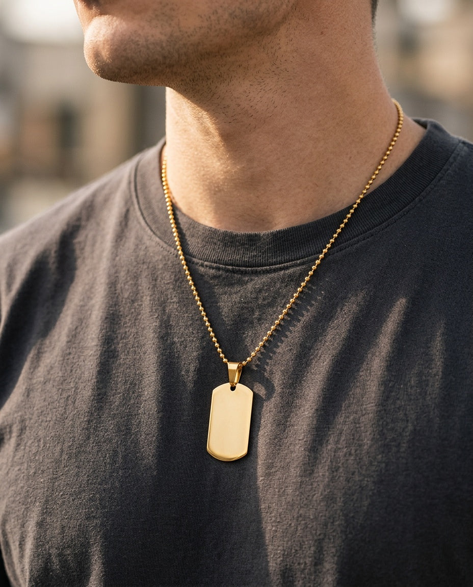 Gold military tag pendant worn over a white T-shirt
