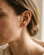 Ear climber earrings worn along the edge of the ear