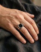 Onyx signet ring worn on a man's ring finger