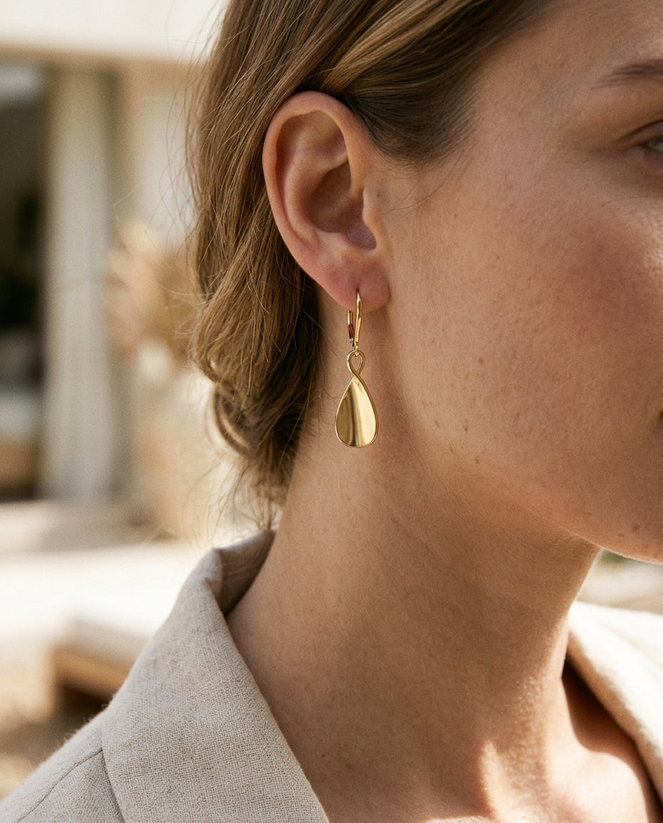 Gold teardrop earrings worn with hair pulled back