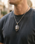 Lion pendant necklace worn by a man over a dark T-shirt