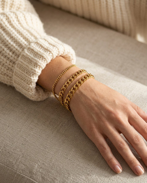 Curb link bracelet worn on a woman's wrist with a watch