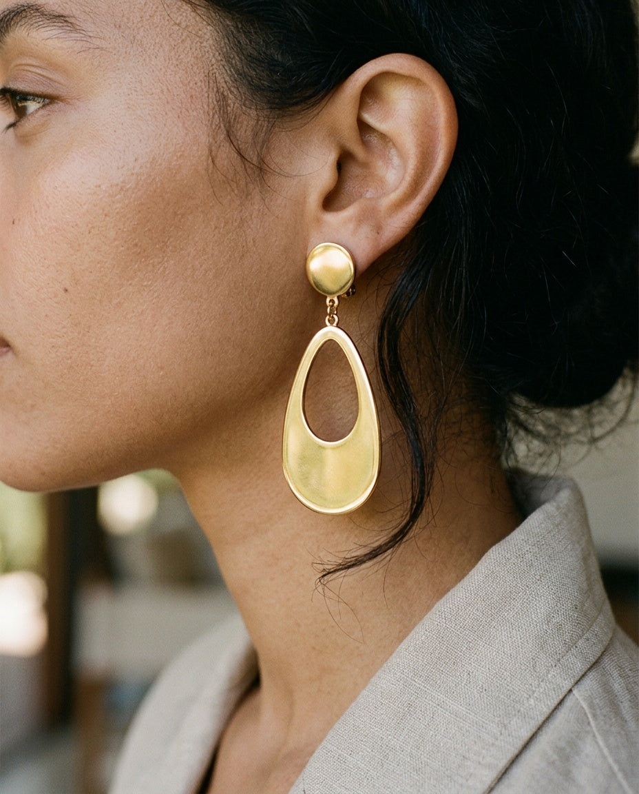 Teardrop clip-on earrings worn with hair tied back