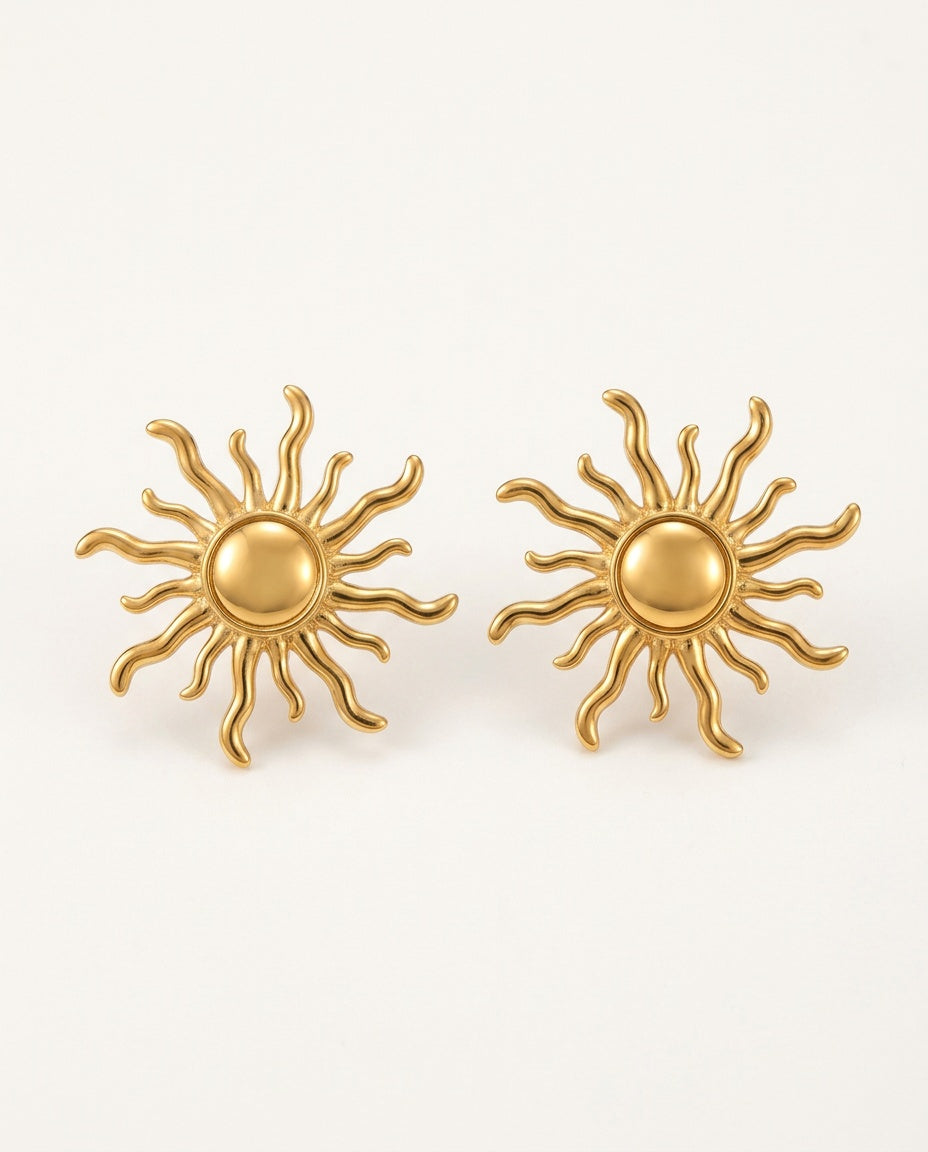 Gold sun earrings, sun stud style, on a white background