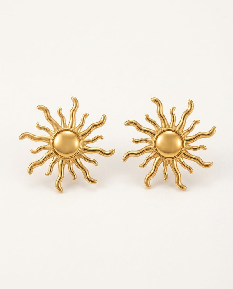 Gold sun earrings, sun stud style, on a white background
