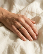 Gold promise ring worn on the ring finger of the left hand