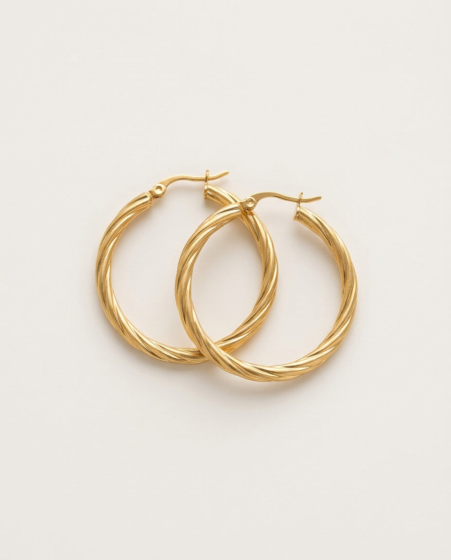 Twisted hoop earrings in gold, 3 mm thick, on a white background