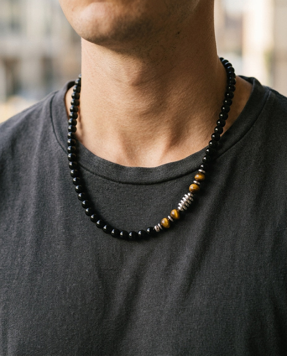 Men's tiger eye necklace worn over a white T-shirt