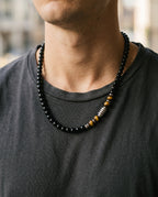 Men's tiger eye necklace worn over a white T-shirt
