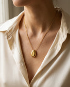 Sautoir pendentif porté sur un pull en maille fine