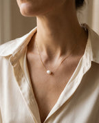 Collier perle de culture porté à la base du cou