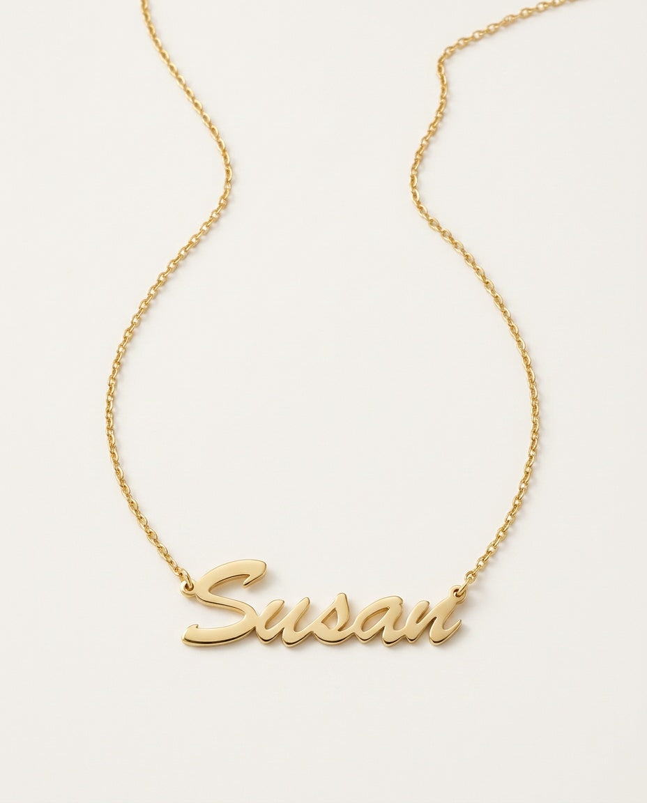 Gold name necklace with a name in flowing script on a fine chain