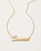 Gold name necklace with a name in flowing script on a fine chain