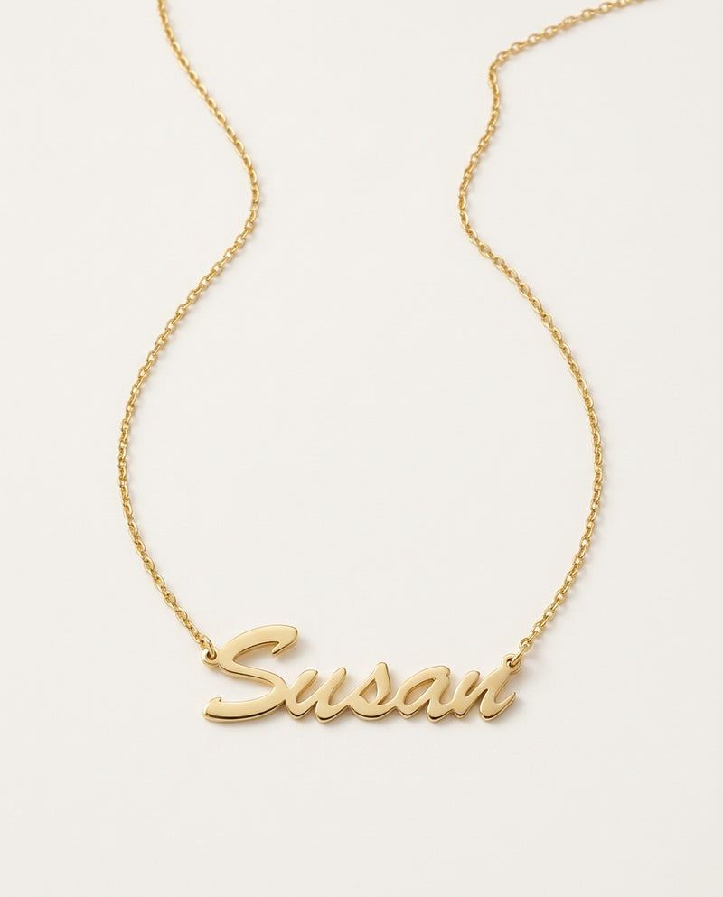 Gold name necklace with a name in flowing script on a fine chain