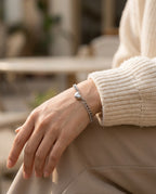 Couple bracelets worn by two people holding hands, hearts joined