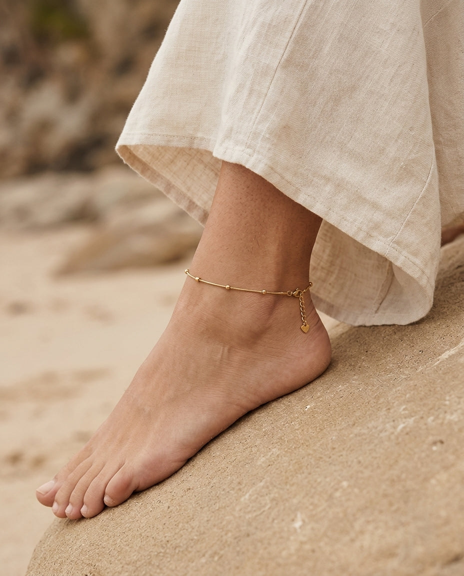 Gold anklet worn on a bare ankle with sandals
