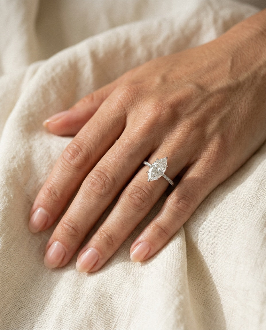 Main portant une bague en argent avec un zircon taille marquise