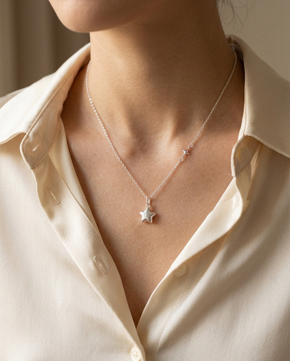Pendentif étoile porté près des clavicules avec un haut blanc