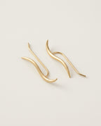Gold ear climber earrings with a fine wavy line in sterling silver