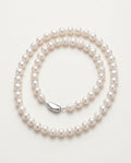 Collier perle blanche en perles baroques d'eau douce sur un présentoir