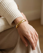 Cuff bracelet worn on a bare wrist with a sleeveless top