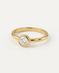 Gold promise ring with a round moissanite in a bezel setting