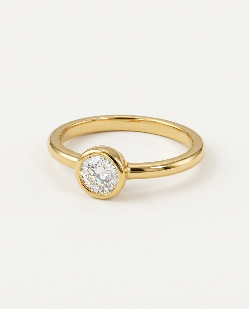 Gold promise ring with a round moissanite in a bezel setting