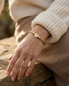 Charm bangle worn on the wrist stacked with a thin bangle