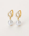 Gold pearl earrings with irregular round pearl drops, on white