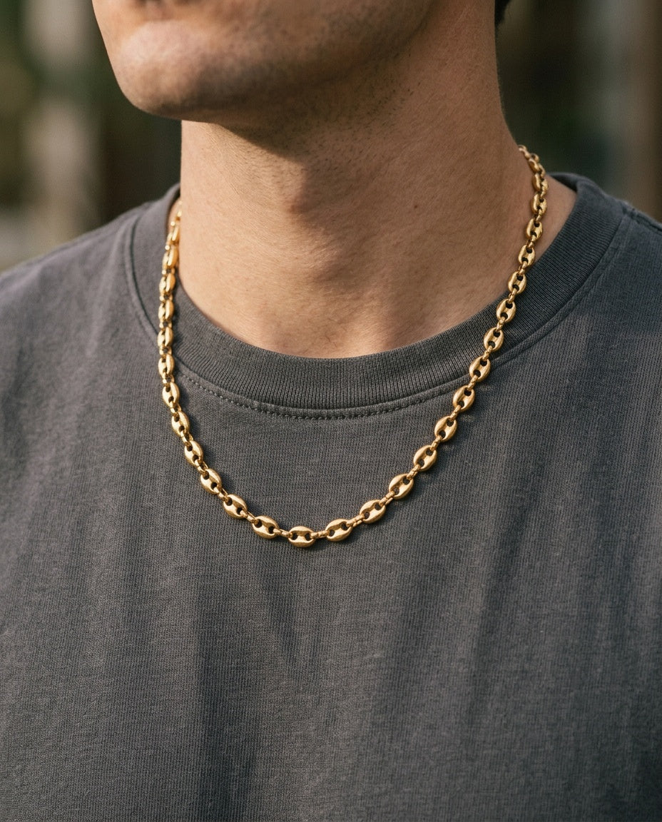 Gold link chain worn over a white T-shirt