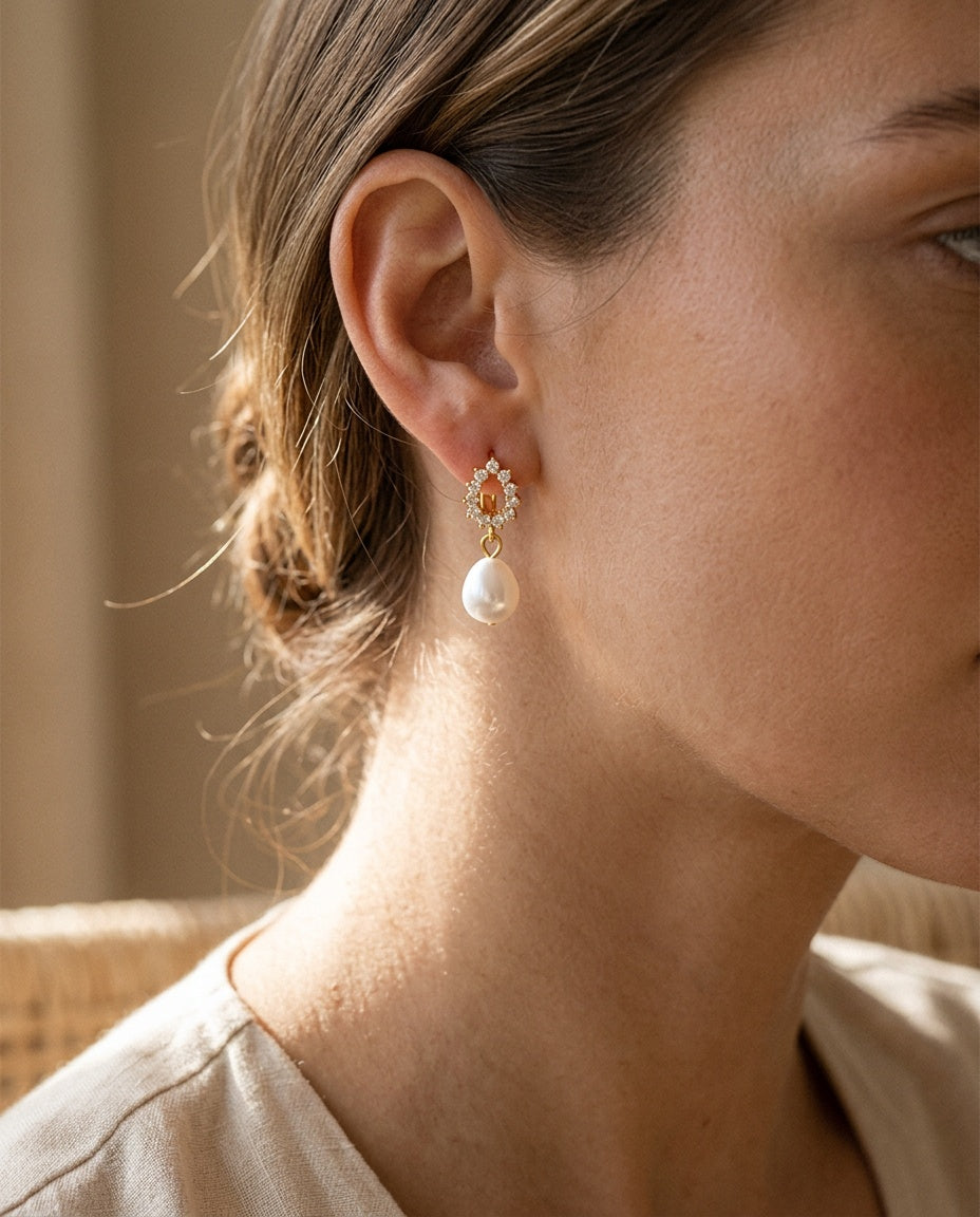 Pearl drop earring worn with hair tucked behind the ear
