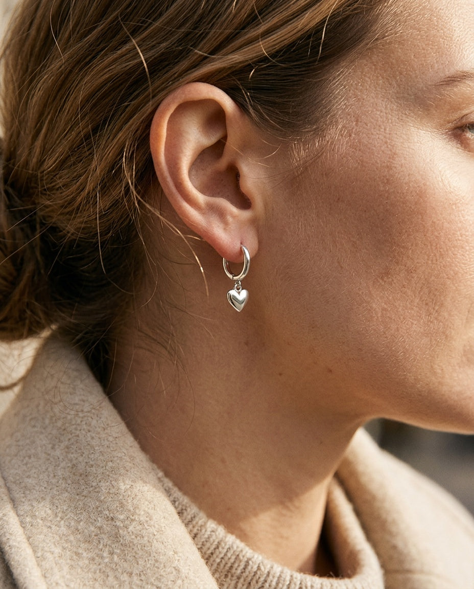 Silver heart earrings worn on the earlobe