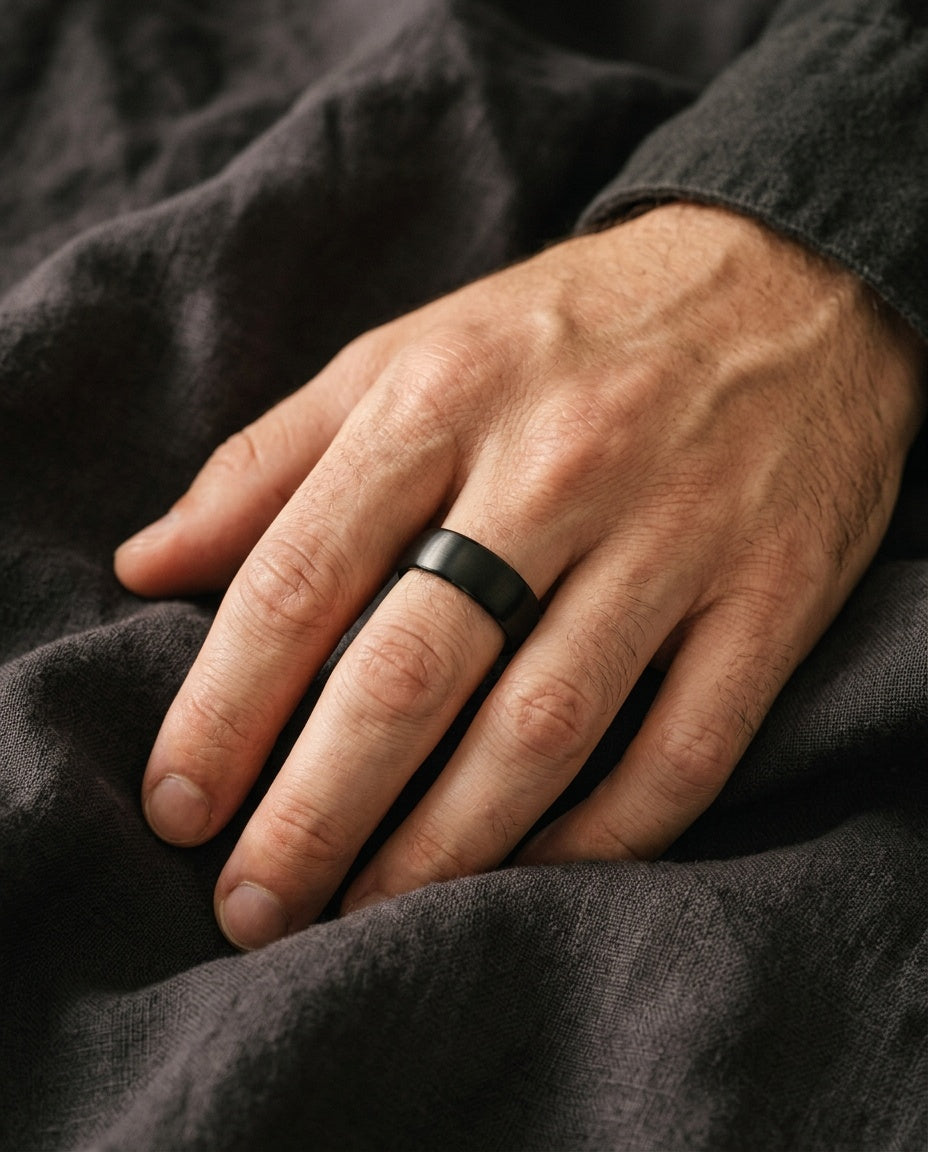 Black ring worn on a man's ring finger