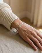 Twisted bangle worn on the wrist next to a watch